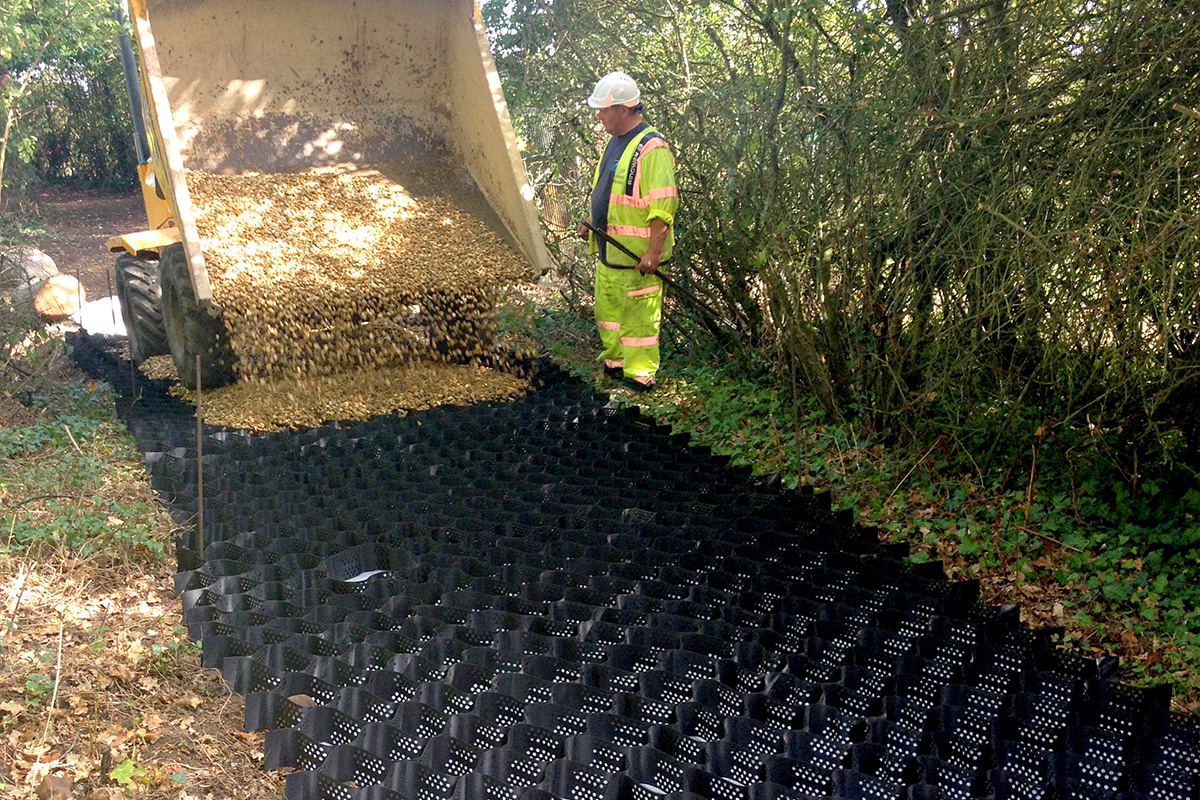 Tree root protection with Protectaweb pouring stone onto a path near trees