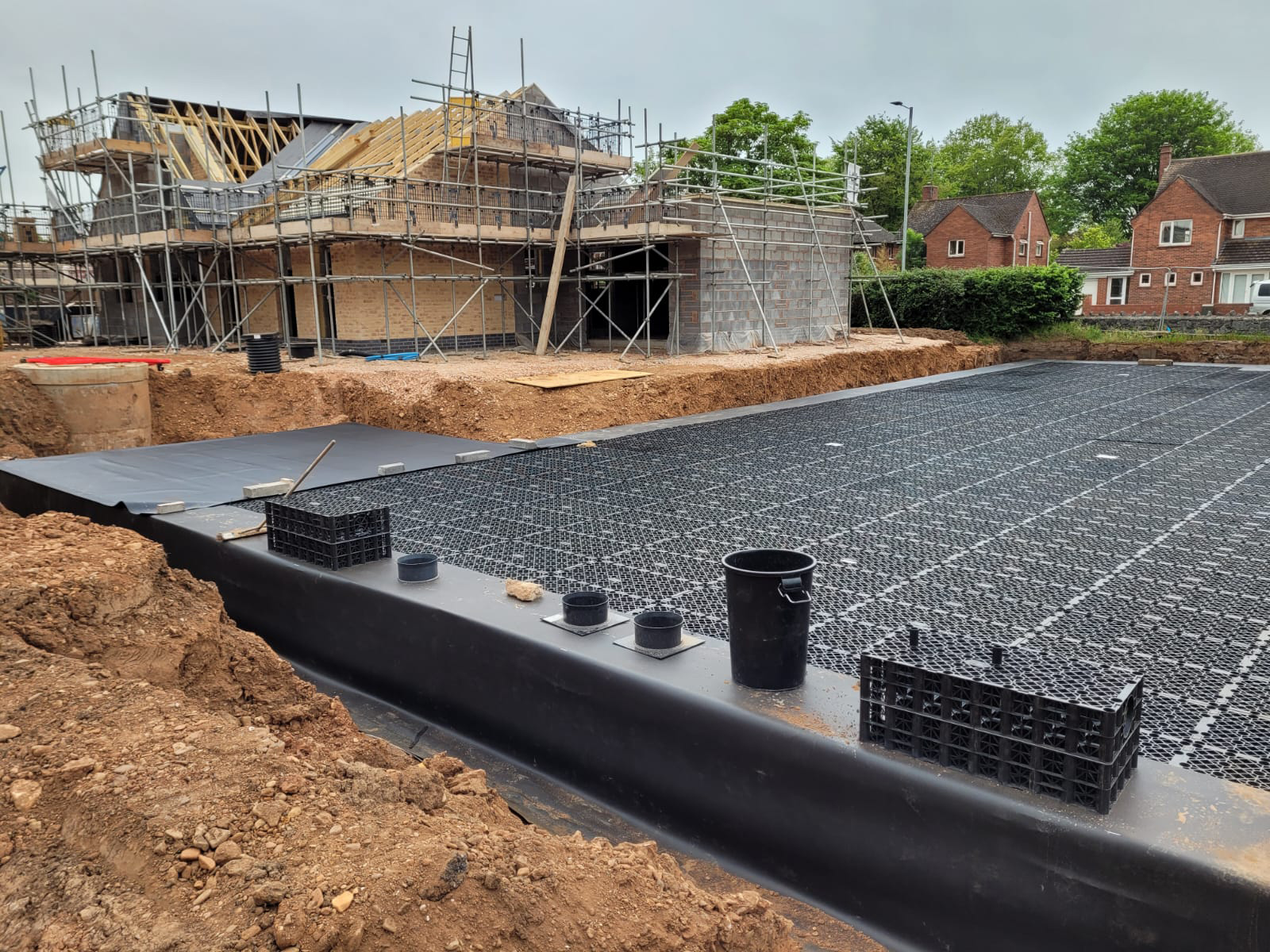 An attenuation tank being constructed next to a house