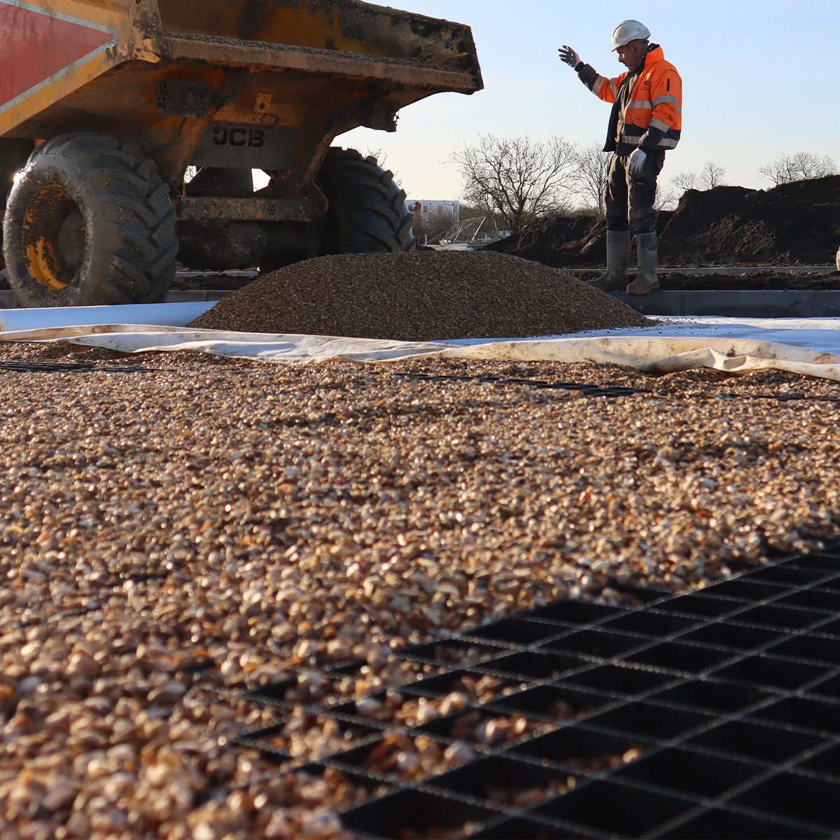 A truck emptying some stone onto Ecodeck