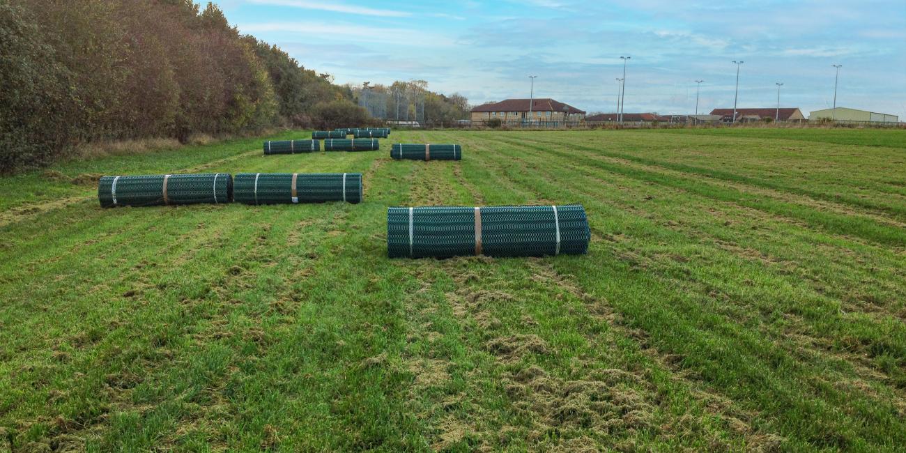 Rolls of TurfMesh in a field, awaiting rollout