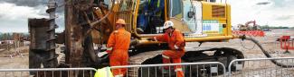 People next to piling rig on construction site