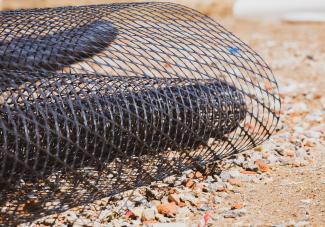 A roll of geogrid over some stones