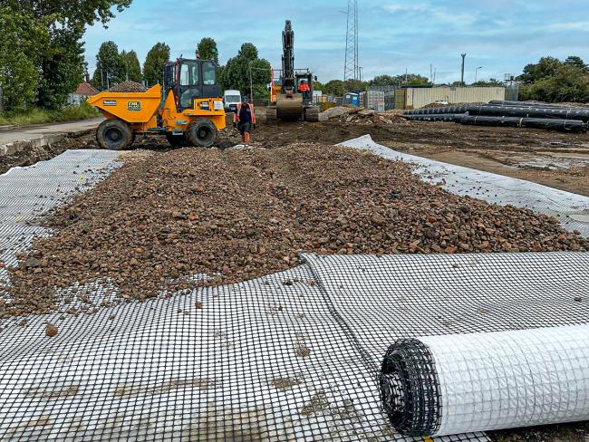 A geocomposite being rolled out for a construction project